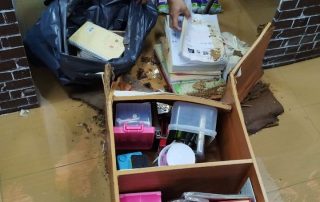 A teacher salvaging books and other materials after the flood