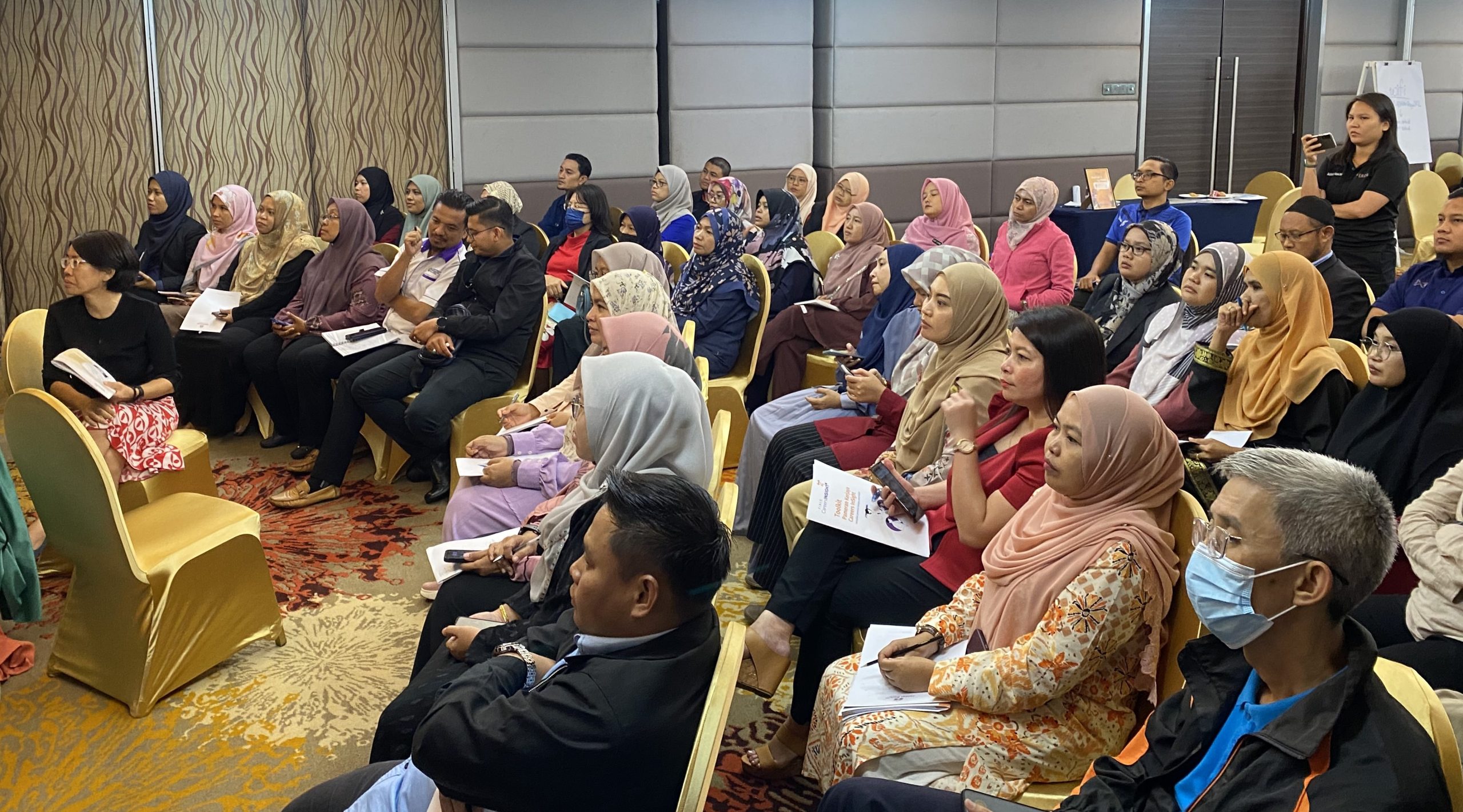 a room full of teachers sitting in rows and looking to the front